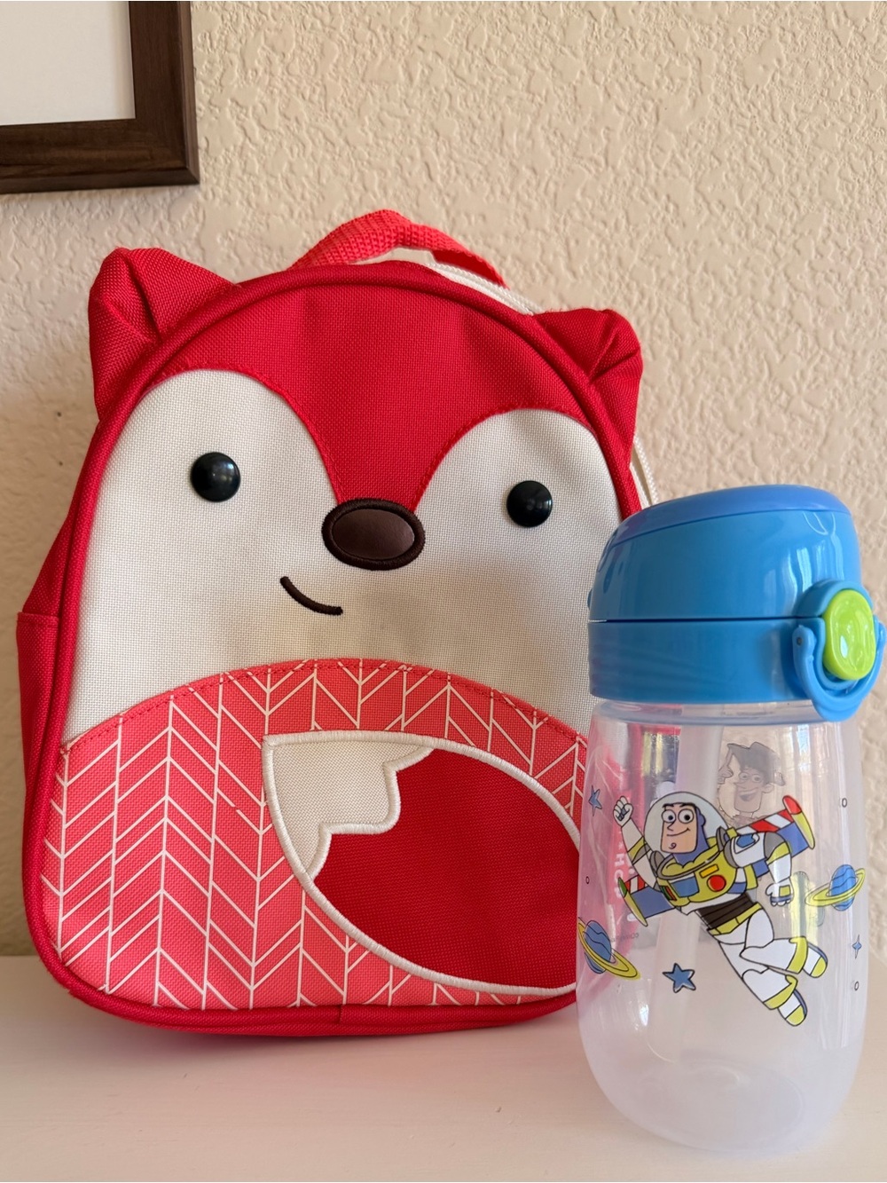 Skip Hop Zoo Mini Backpack with Blue and Toy Story Sippy Cup.